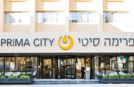 Prima City Hotel Tel Aviv entrance. Gay-friendly hotel featuring a revolving door, plants, and a modern design. Ideal for gay travel.
