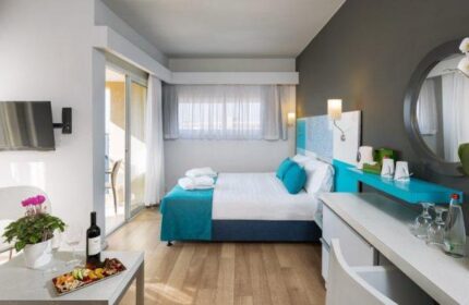 Prima City Hotel Tel Aviv room. Modern gay-friendly hotel bedroom with double bed, balcony, TV, wine, and snacks. Great for gay travel.