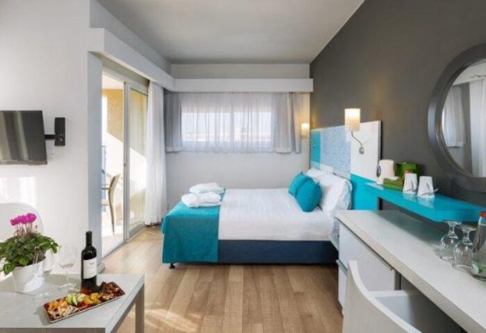 Prima City Hotel Tel Aviv room. Modern gay-friendly hotel bedroom with double bed, balcony, TV, wine, and snacks. Great for gay travel.