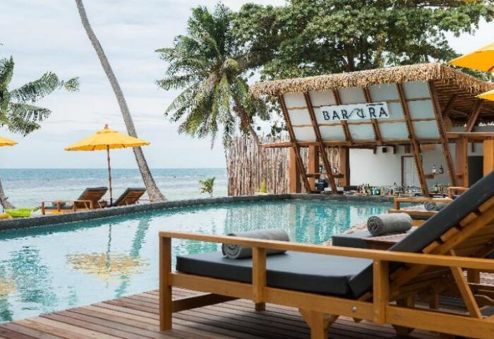 Princess Paradise Koh Phangan gay-friendly hotel pool view. Bar area, lounge chairs, & ocean scenery. Ideal for gay men's travel in Thailand.