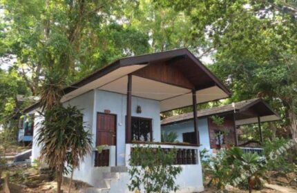 Pudsa Bungalow, a gay-friendly hotel. Exterior view of the bungalows, nestled among lush greenery. Ideal for gay travel and relaxation.