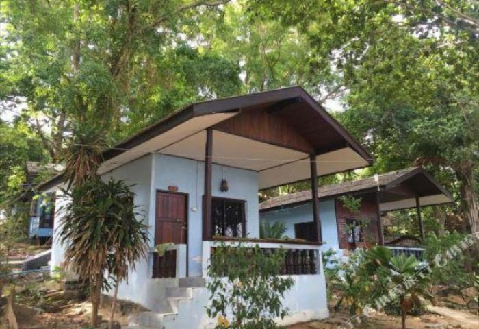 Pudsa Bungalow, a gay-friendly hotel. Exterior view of the bungalows, nestled among lush greenery. Ideal for gay travel and relaxation.