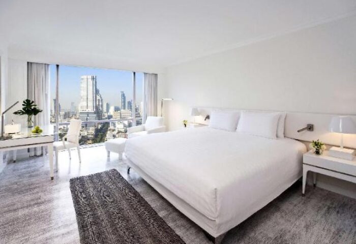 Pullman Bangkok Hotel G room. Modern, bright interior with a large bed, desk, and city view. Gay-friendly hotel for LGBTQ+ travelers in Bangkok.