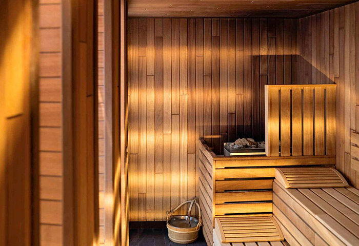 Sauna at the Gay-Friendly Pullman Berlin Schweizerhof Hotel. Wooden benches, walls, and bucket. Relaxing spa experience for gay travelers.