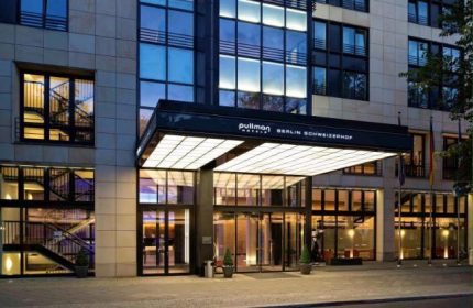 Pullman Berlin Schweizerhof Hotel entrance. Gay-friendly hotel in Berlin, Germany. Modern architecture with glass and steel. Upscale travel.