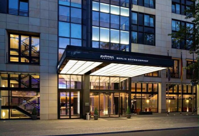 Pullman Berlin Schweizerhof Hotel entrance. Gay-friendly hotel in Berlin, Germany. Modern architecture with glass and steel. Upscale travel.