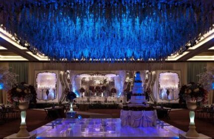 Pullman Jakarta Central Park Hotel ballroom with blue lighting, stage, and cake. Gay-friendly hotel for weddings and events.