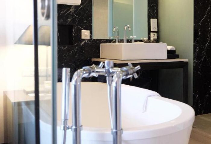 Pullman Jakarta, Indonesia gay-friendly hotel bathroom. Features a modern bathtub, sink, and marble accents. Ideal for gay travelers.