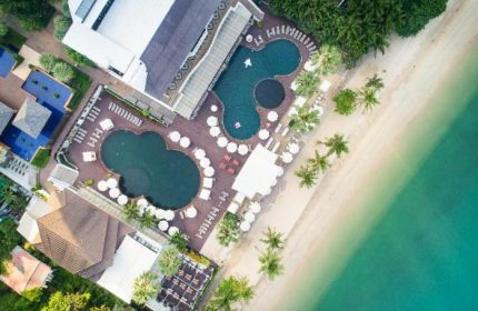 Aerial view of Pullman Pattaya Hotel G, a gay-friendly hotel. Pools, beach, and palm trees offer a luxurious resort experience.