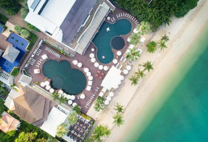 Aerial view of Pullman Pattaya Hotel G, a gay-friendly hotel. Pools, beach, and palm trees offer a luxurious resort experience.