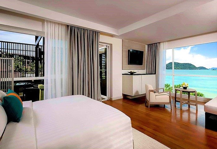 Pullman Phuket Panwa Beach Resort room. Gay-friendly SHA-certified hotel with ocean view, bed, TV, and seating area. Ideal for gay travel.