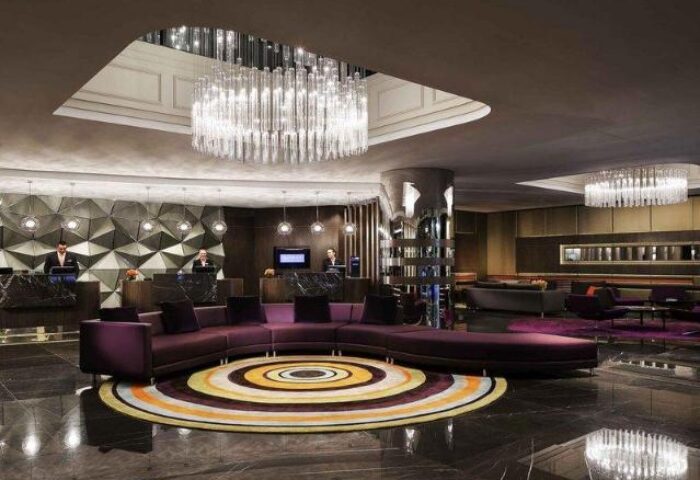 Pullman Sydney Hyde Park lobby. Gay-friendly hotel with modern design, chandeliers, and circular seating. Upscale travel for gay men in Sydney.