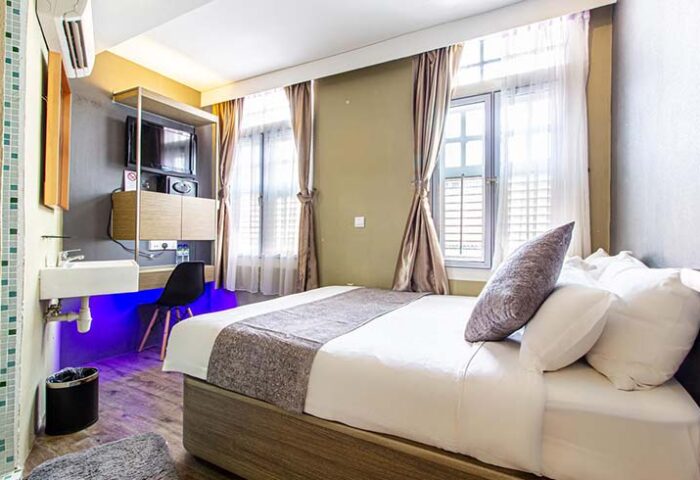 Q Loft Hotel1929@Chinatown room. Gay-friendly hotel with bed, desk, TV, sink. Modern design, natural light. Ideal for gay men travel in Chinatown.