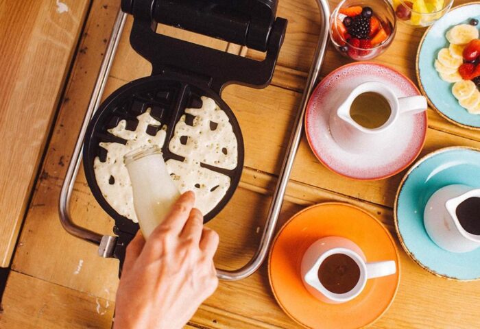 Waffle making at gay-friendly Qbic London City hotel. Breakfast with fruit, syrup. Pet-friendly hotel, delicious food.