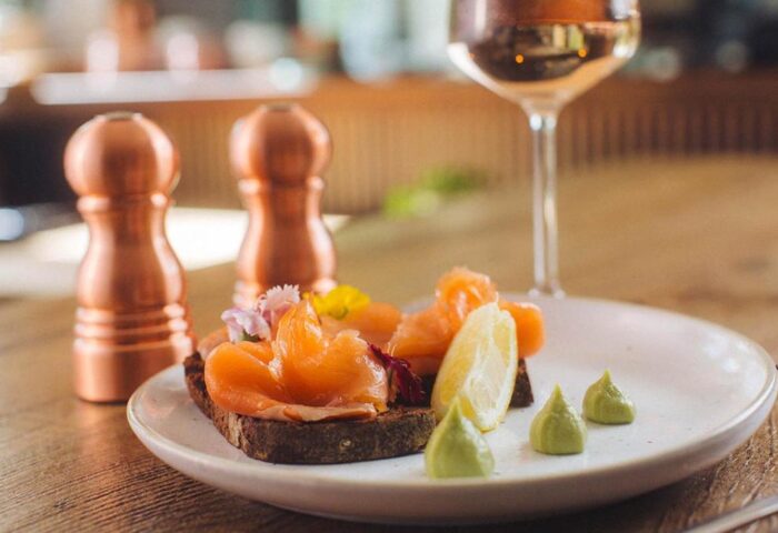 Qbic London City gay-friendly hotel: Smoked salmon on toast with lemon, wasabi, and a glass of wine. Copper salt and pepper shakers.
