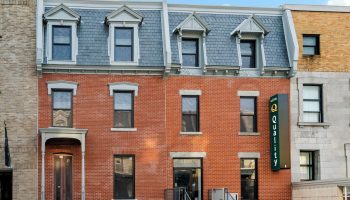 Quality Inn Centre-Ville, a gay-friendly hotel. Red brick building with a Quality Hotel sign. A great choice for gay travel in the city center.