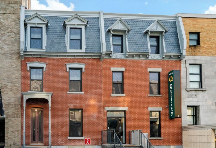 Quality Inn Centre-Ville, a gay-friendly hotel. Red brick building with a Quality Hotel sign. A great choice for gay travel in the city center.