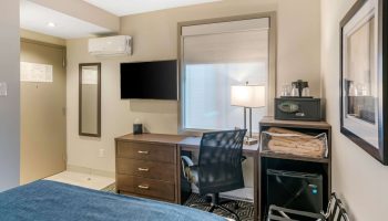 Quality Inn Centre-Ville hotel room. Desk, TV, safe, mini-fridge, and bed. Gay-friendly hotel for gay men travel advice.