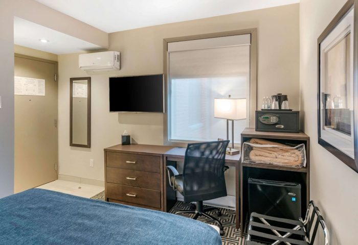 Quality Inn Centre-Ville hotel room. Desk, TV, safe, mini-fridge, and bed. Gay-friendly hotel for gay men travel advice.