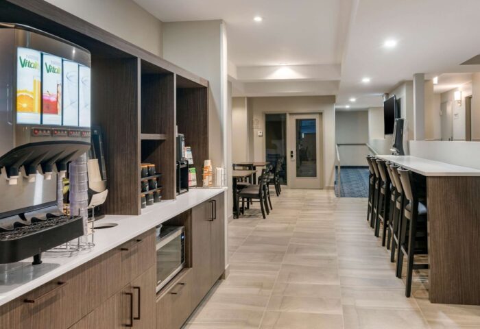 Quality Inn Centre-Ville's gay-friendly hotel breakfast bar. Juice dispenser, microwave, coffee, seating. Perfect for gay travelers.