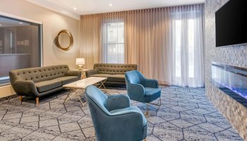 Quality Inn Centre-Ville's stylish lounge area. Sofas, blue chairs, and modern decor create a welcoming space in this gay-friendly hotel.