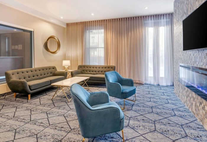 Quality Inn Centre-Ville's stylish lounge area. Sofas, blue chairs, and modern decor create a welcoming space in this gay-friendly hotel.