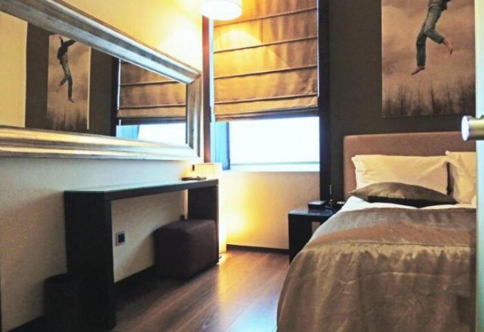 Bedroom at Quentin Design Hotel Berlin, a gay-friendly hotel. Room features a large mirror, desk, bed, and modern art. Ideal for gay travelers.