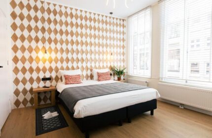 Quentin Golden Bear Hotel room. Gay-friendly hotel with diamond pattern wall, bed, and windows. Ideal for gay men travel.