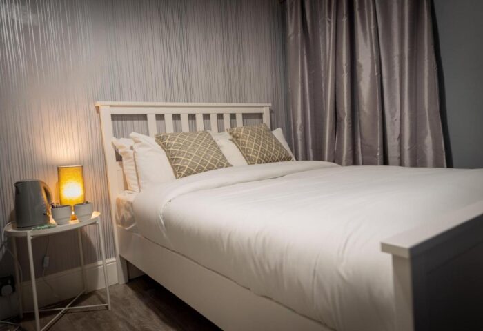 REM Hotel's bedroom. Gay-friendly hotel room with a double bed, bedside table, lamp, and kettle. Modern hotel for gay travelers.