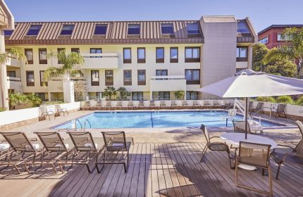 RIU Plaza Fisherman's Wharf gay-friendly hotel pool. Lounge chairs and tables surround the pool. A great place to relax in San Francisco.