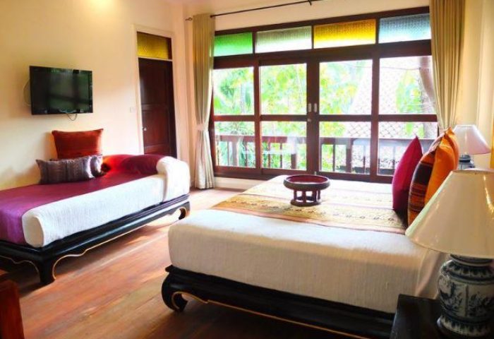 Rabbit Resort gay-friendly hotel room interior. Twin beds, colorful window, & TV. A welcoming space for gay travelers seeking comfort.