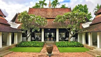 Rachamankha Hotel, a Relais & Châteaux member. Gay-friendly hotel exterior with red brick path, lush greenery, and classic Thai architecture.