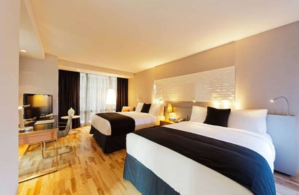 Radisson Blu Aqua Hotel, Chicago guest room. Gay-friendly hotel with two beds, TV, desk, wood floors, and modern decor. Perfect for gay travelers.