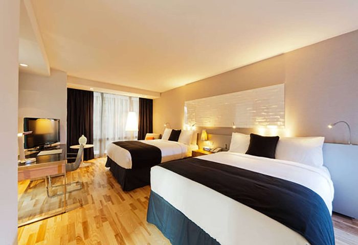 Radisson Blu Aqua Hotel, Chicago guest room. Gay-friendly hotel with two beds, TV, desk, wood floors, and modern decor. Perfect for gay travelers.