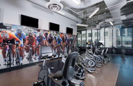 Radisson Blu Aqua Hotel, Chicago gym. Gay-friendly hotel featuring exercise bikes and a cycling race mural. Fitness for gay travelers.