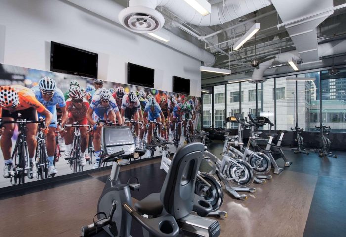 Radisson Blu Aqua Hotel, Chicago gym. Gay-friendly hotel featuring exercise bikes and a cycling race mural. Fitness for gay travelers.