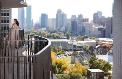 Radisson Blu Aqua Hotel, Chicago: Woman on balcony. Skyline view from gay-friendly hotel. Luxury travel destination.