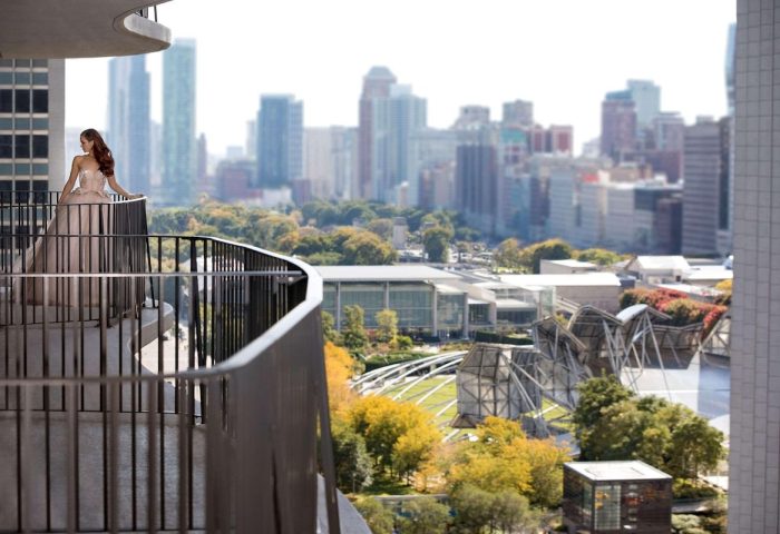 Radisson Blu Aqua Hotel, Chicago: Woman on balcony. Skyline view from gay-friendly hotel. Luxury travel destination.