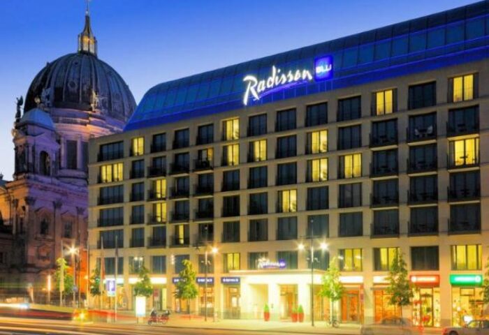 Radisson Collection Hotel, Berlin. Gay-friendly Radisson Blu Hotel exterior view at dusk. A top choice for gay travelers in Berlin.