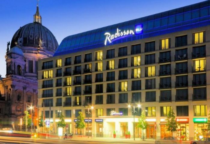 Radisson Collection Hotel, Berlin. Gay-friendly Radisson Blu Hotel exterior view at dusk. A top choice for gay travelers in Berlin.