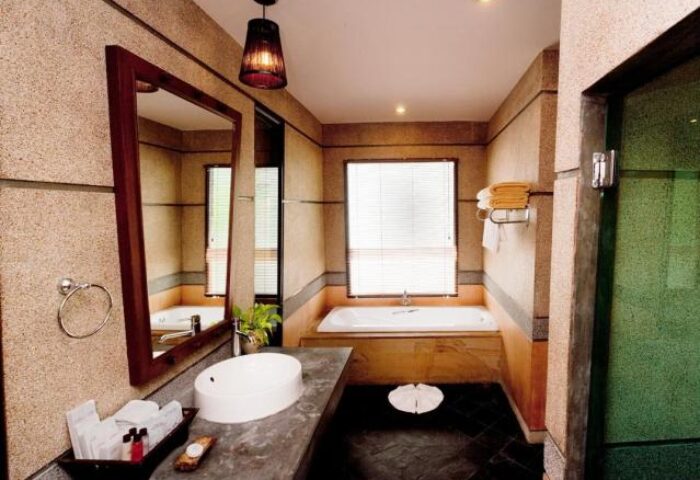 Bathroom at Gay-Friendly Railay Village Resort: Modern design with a bathtub, sink, and mirror. A luxury hotel for gay men travelers.