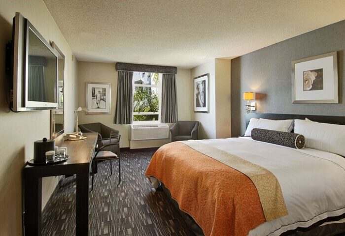Hotel room at Ramada Plaza by Wyndham West Hollywood Hotel & Suites. Gay-friendly hotel with a comfortable bed, TV, desk, and seating area.