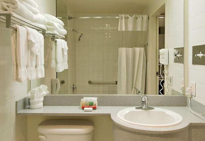 Bathroom at Ramada Plaza by Wyndham West Hollywood Hotel & Suites, a gay-friendly hotel. Sink, shower, and towels are visible.