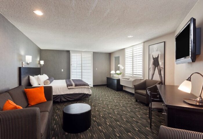Ramada Plaza by Wyndham West Hollywood Hotel & Suites room. Gay-friendly hotel suite with bed, sofa, desk, and TV. West Hollywood lodging.