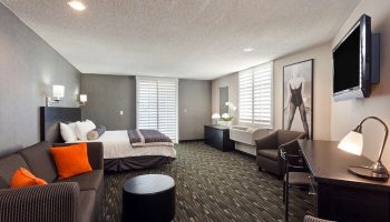 Ramada Plaza by Wyndham West Hollywood Hotel & Suites room. Gay-friendly hotel suite with bed, sofa, desk, and TV. West Hollywood lodging.