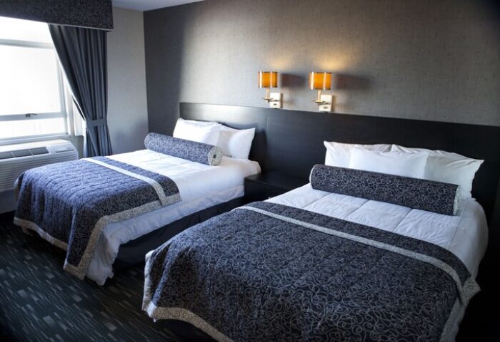 Ramada Plaza by Wyndham West Hollywood Hotel & Suites: Two beds in a gay-friendly hotel room with dark gray walls and blue patterned bedspreads.