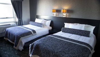 Ramada Plaza by Wyndham West Hollywood Hotel & Suites: Two beds in a gay-friendly hotel room with dark gray walls and blue patterned bedspreads.
