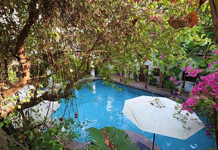 Rambutan Resort Siem Reap pool view. Gay-friendly hotel with lush greenery, swimming pool, and relaxing atmosphere. Ideal for gay travel.