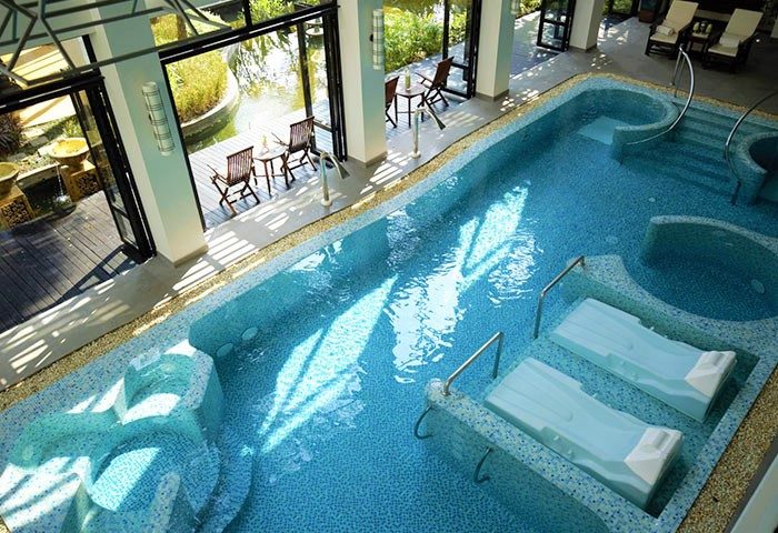 RarinJinda Wellness Spa Resort pool. Gay-friendly hotel's serene blue tiled pool with sun loungers. A perfect gay travel destination.