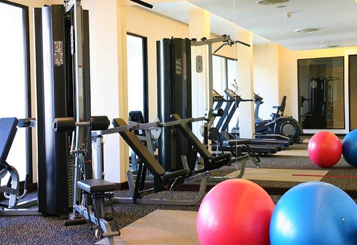 RarinJinda Wellness Spa Resort gym with weights, treadmills, and exercise balls. Gay-friendly hotel fitness center for a healthy vacation.